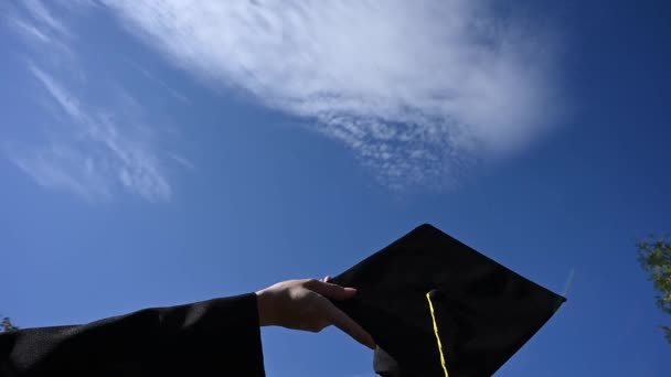 空に卒業キャップを投げ女性の手のクローズアップ — ストック動画