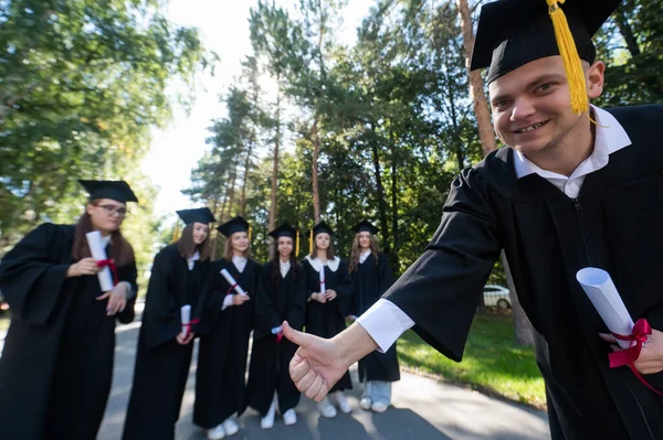 Szczęśliwy Młody Biały Absolwent Pokazywał Kciuki Góry Grupa Absolwentów Świeżym — Zdjęcie stockowe