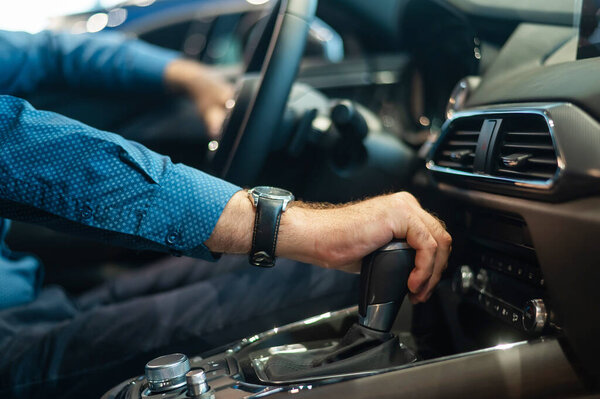 Close-up of a mans hand while shifting the automatic transmission of a car