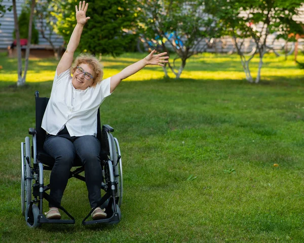 上了年纪的高加索女人坐在轮椅上做运动 — 图库照片