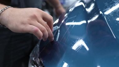 Araba servisindeki usta arabaya zırh filmi uyguluyor.