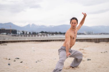 Beyaz adam dışarıda dövüş sanatları yapıyor. denge ve meditasyon