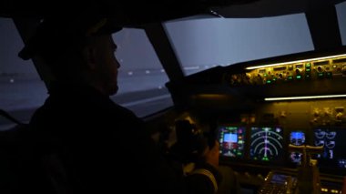 A man is studying to be a pilot in an aircraft simulator