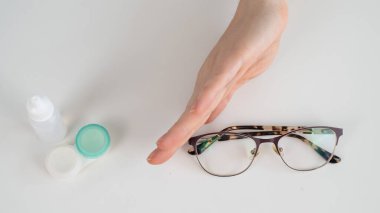 Bir kadın gözlük ve lens arasında seçim yapar. Kararları değerlendirir ve gözlükleri seçer.