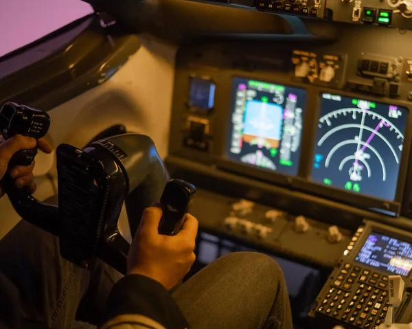 A man is studying to be a pilot in a flight simulator. Close-up of male hands navigating an aircraft