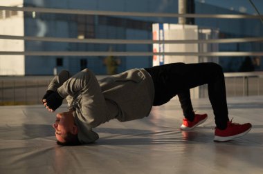 Caucasian male boxer warming up before a fight in the ring outdoors