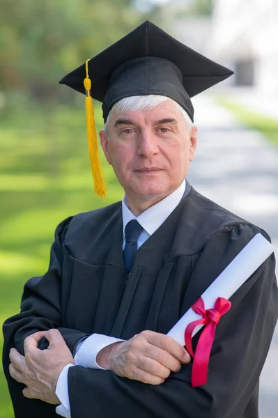 Portret Starszego Mężczyzny Sukni Dyplomowej Dyplomem Zewnątrz Pionowe — Zdjęcie stockowe