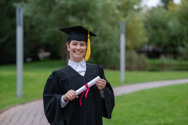 Portrait Happy Caucasian Woman Graduate Gown Holding Diploma Outdoors — Zdjęcie stockowe