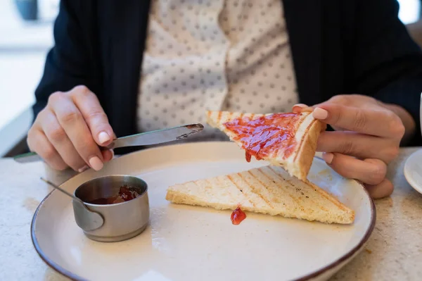 stock image Close-up. Business woman spreads jam on toast in an outdoor cafe