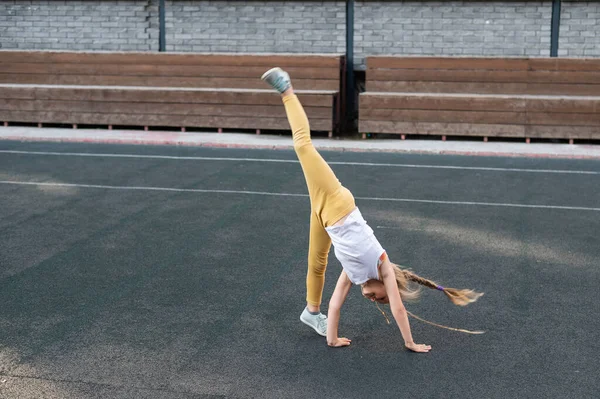 Καυκάσια Κοπέλα Κάνει Μια Ρόδα Στο Γήπεδο Του Αθλητισμού Εξωτερικούς — Φωτογραφία Αρχείου