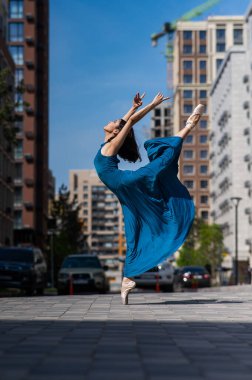 Dışarıda dans eden güzel bir Asyalı balerin. Şehir manzarası