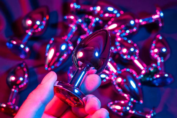 stock image Man holding metal anal plug in neon pink purple light