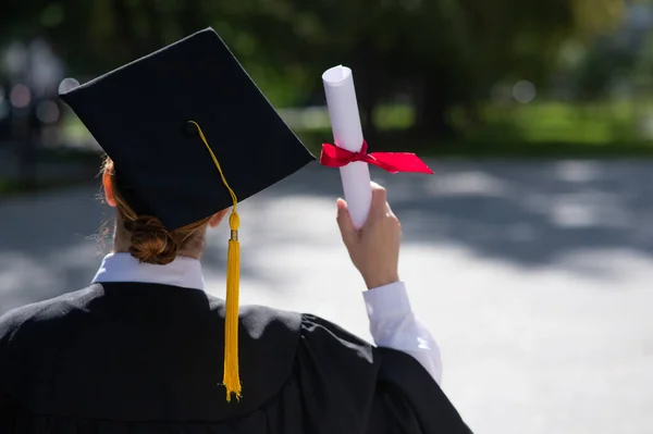 Rear View Caucasian Woman Graduate Gown Holding Diploma Outdoors — Φωτογραφία Αρχείου