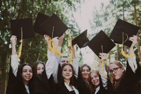 Classmates Graduation Gowns Throwing Hats Outdoors — Stock Photo, Image