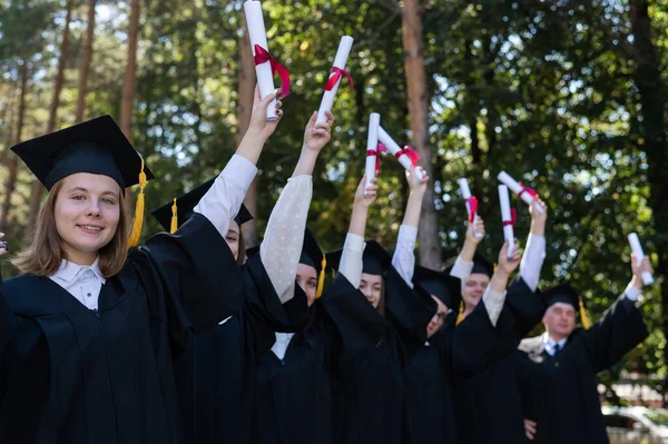 Een Groep Afgestudeerden Gewaden Hief Hun Handen Met Diploma Buiten — Stockfoto