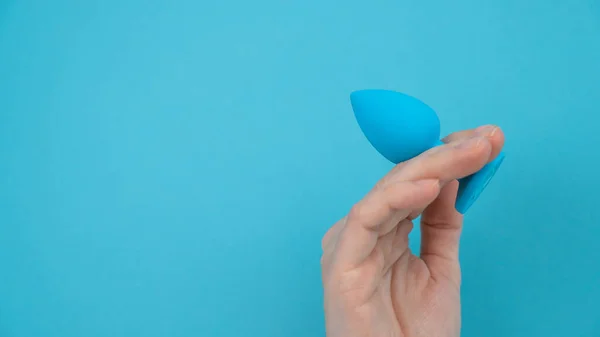 stock image Woman holding a blue anal plug on a blue background