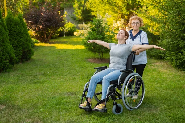 Elderly Nurse Walks Middle Aged Woman Wheelchair Park Girl Spread — Stockfoto