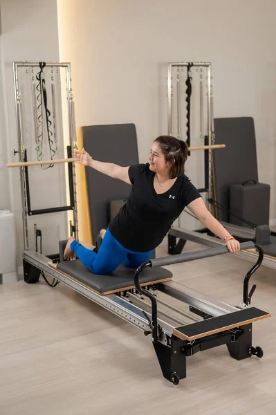 Aşırı Kilolu Beyaz Kadın Bir Reformcu Üzerinde Pilates Egzersizi Yapıyor — Stok fotoğraf