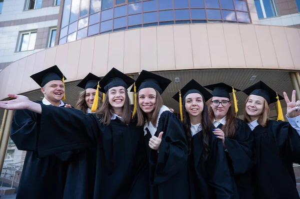 Mezuniyet Elbisesi Giymiş Mutlu Öğrenciler Üniversitenin Arka Planına Karşı Sıraya — Stok fotoğraf