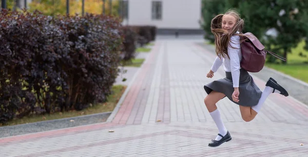 Menina Caucasiana Feliz Uniforme Com Uma Mochila Pulando Livre Depois — Fotografia de Stock