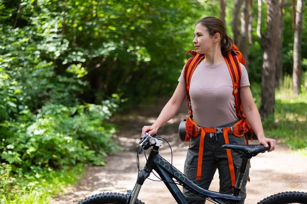 白人妇女在森林里骑自行车 — 图库照片