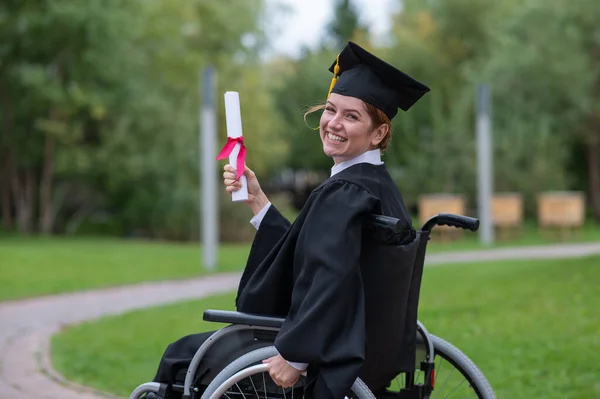 Happy Caucasian Woman Wheelchair Turns Holds Her Diploma Outdoors — Foto Stock