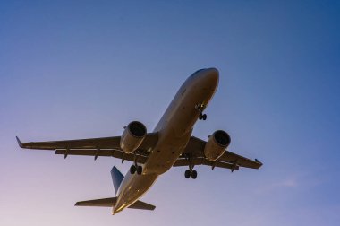 Mavi gökyüzüne karşı uçan bir uçağın alt görüntüsü