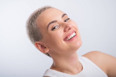 Beyaz arka planda kısa saç kesimi olan güzel beyaz bir kadın.