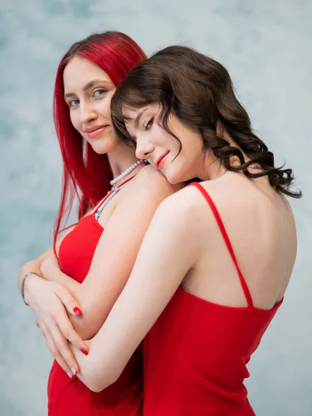 Ett Närporträtt Två Ömt Omfamnande Kvinnor Klädda Identiska Röda Klänningar — Stockfoto