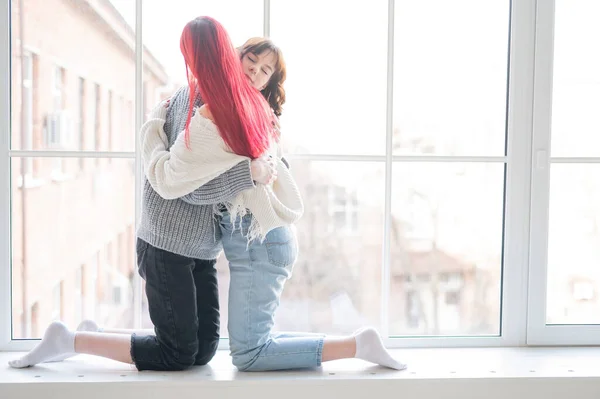 Duas Mulheres Vestidas Com Suéteres Sentam Janela Abraçam Gentilmente Intimidade — Fotografia de Stock
