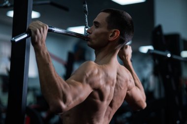 A man does a chest pulldown in the gym