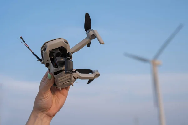 Mulher Segurando Drone Caiu Contra Pano Fundo Dos Moinhos Vento — Fotografia de Stock