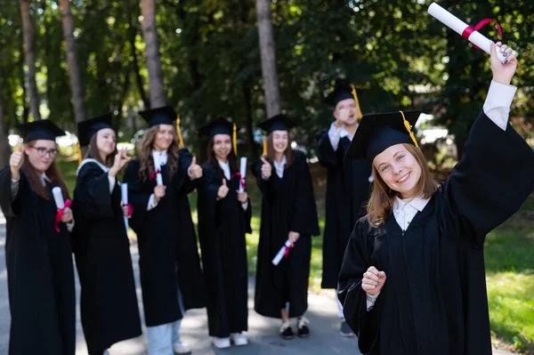 Группа Счастливых Студентов Выпускных Платьях Открытом Воздухе Молодая Девушка Дипломом — стоковое фото