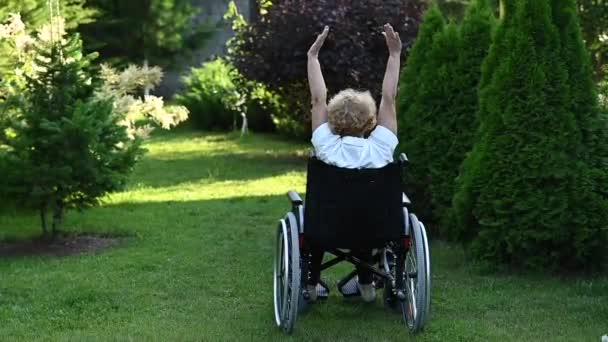 Mulher Idosa Caucasiana Fazendo Exercícios Enquanto Sentada Uma Cadeira Rodas — Vídeo de Stock