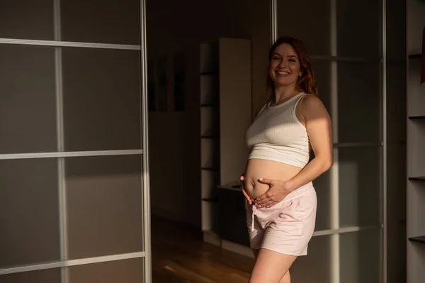 Беременная Женщина Шортах Топе Стоит Профиль Между Складными Дверями — стоковое фото