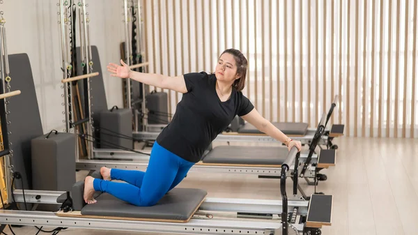 Aşırı Kilolu Beyaz Kadın Bir Reformcu Üzerinde Pilates Egzersizi Yapıyor — Stok fotoğraf