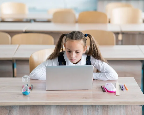 Běloška Sedí Stolem Škole Studuje Laptopu Přesýpací Hodiny Stole — Stock fotografie