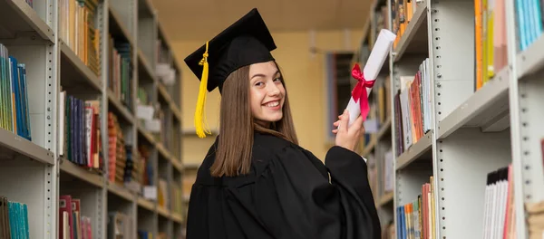 Gelukkige Jonge Vrouw Afgestudeerde Jurk Met Diploma Bibliotheek Breedbeeld — Stockfoto