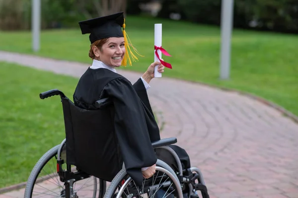 Happy Caucasian Woman Wheelchair Turns Holds Her Diploma Outdoors — Foto Stock
