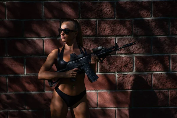 Una Mujer Caucásica Bikini Sostiene Una Ametralladora Contra Una Pared — Foto de Stock