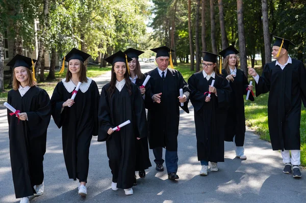 Gruppo Laureati Vesti Con Diplomi Mano Cammina All Aperto Studente — Foto Stock