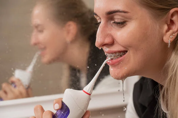 Kobieta Aparatem Zębach Używa Nawadniacza Portret Bliska — Zdjęcie stockowe