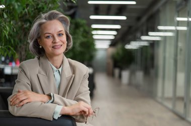 Attractive mature woman sitting on sofa in lobby