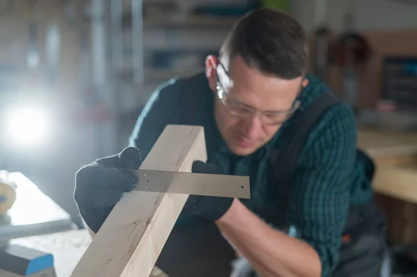 Carpentiere Misura Una Tavola Legno Mentre Lavora Laboratorio — Foto Stock