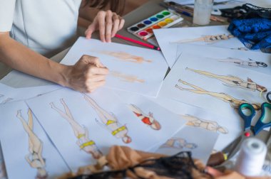 Yüzü olmayan kadın mayo çizimleri çiziyor. Bir moda tasarımcısının ellerine yakın çekim