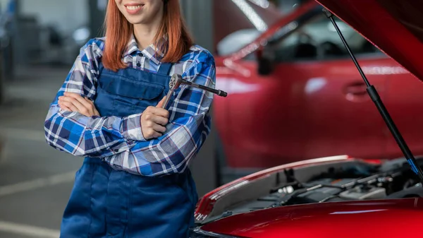 Egy Női Autószerelő Áll Egy Autó Nyitott Motorháztetőjénél Egy Csavarhúzót — Stock Fotó