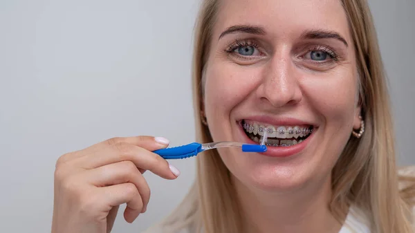 Biała Kobieta Myje Zęby Aparatem Zęby Szczotką — Zdjęcie stockowe