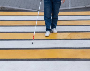 Yaya geçidinden sopayla geçen kör bir kadının bacaklarına yakın çekim.