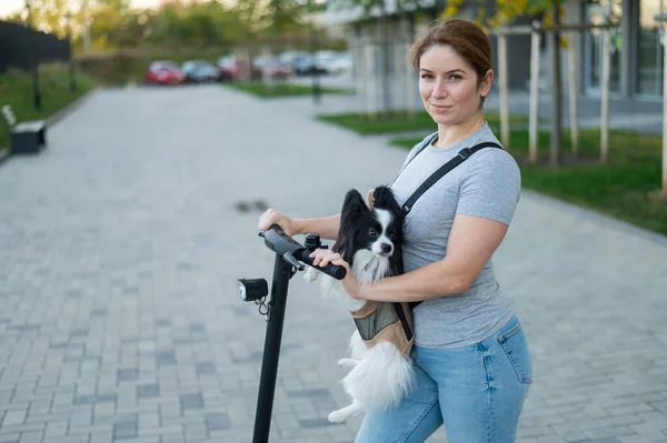 Eine Frau Fährt Mit Einem Hund Rucksack Auf Einem Elektroroller — Stockfoto