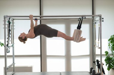 Reformcuda pilates yapan hamile bir kadın.